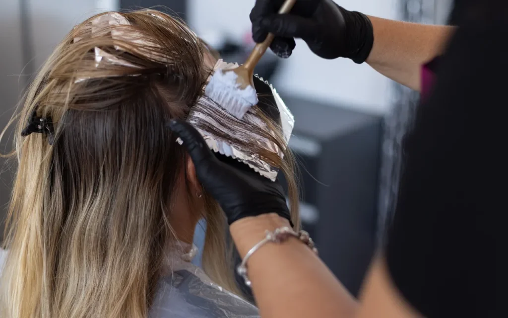 cosmetology student highlighting hair