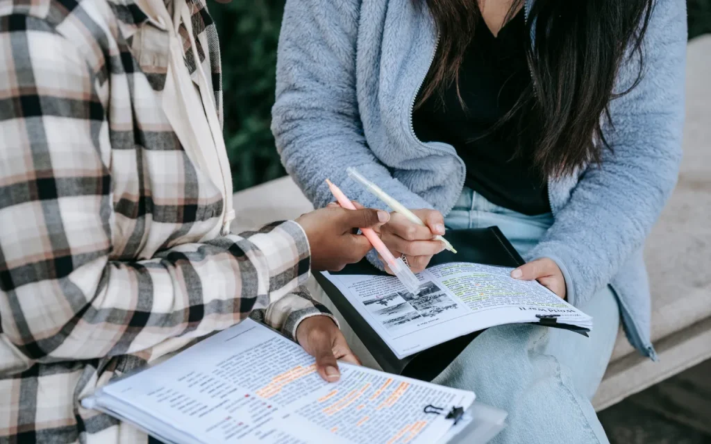 students studying together on a campus bench