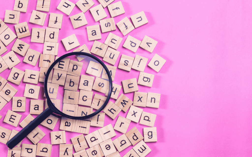 magnifying glass over alphabet tiles