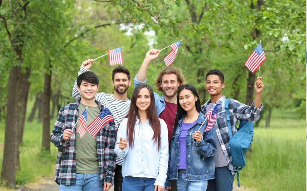 diverse group of students pose with american flags