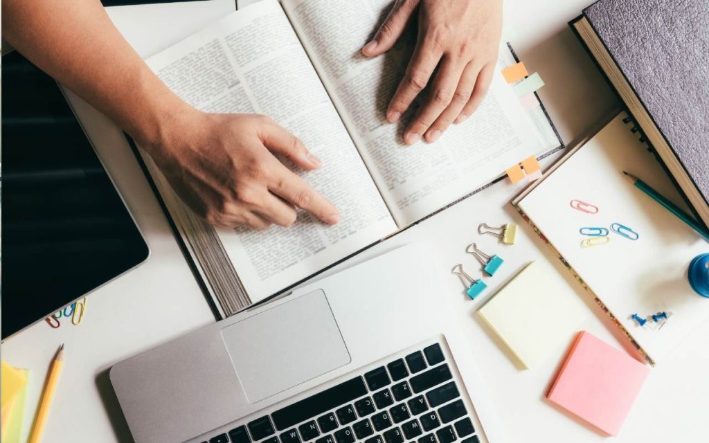 student studies textbook and marks pages