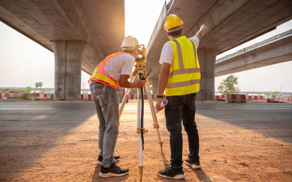 two engineering students take measurements for an overpass