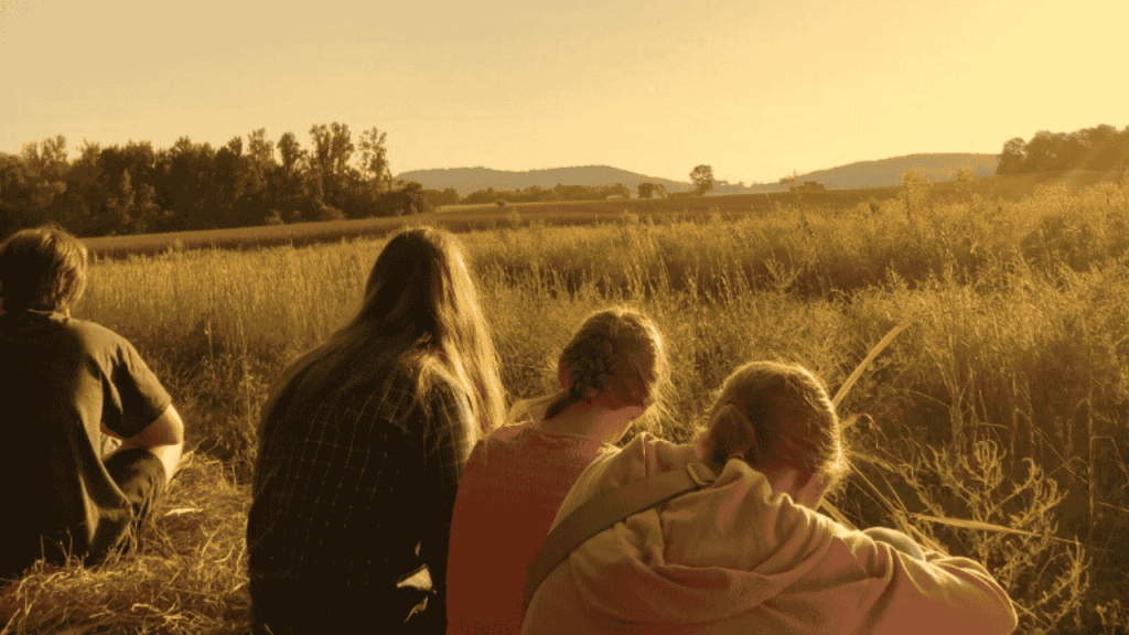 female students sit in wheat field