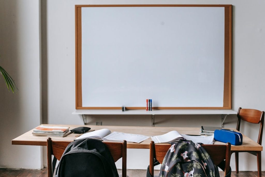 whiteboard and backpacks in empty classroom