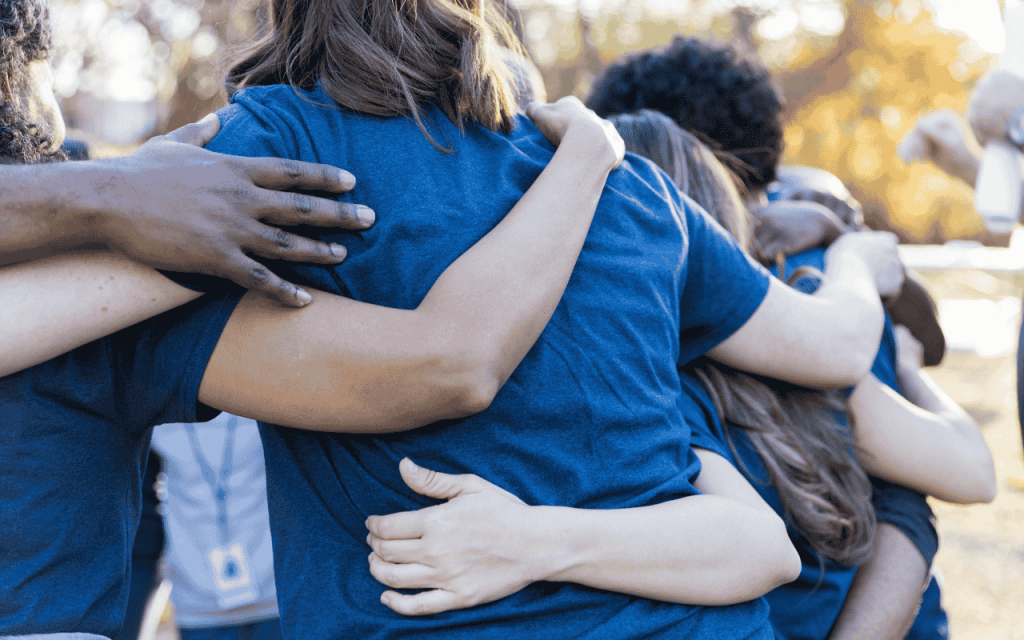 north carolina students wearing blue shirts huddle together