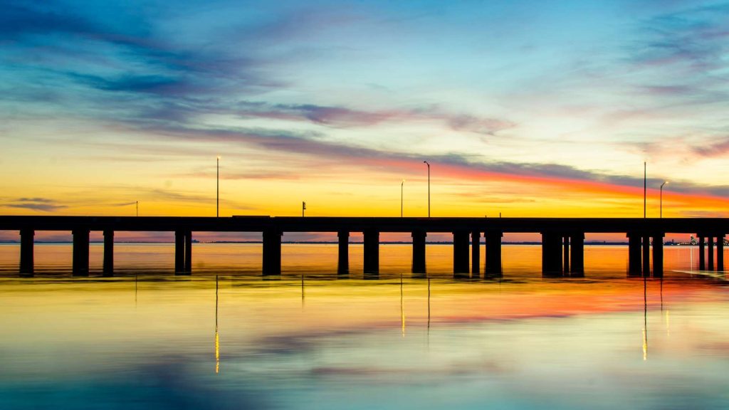 bridge silhouetted against sunset sky