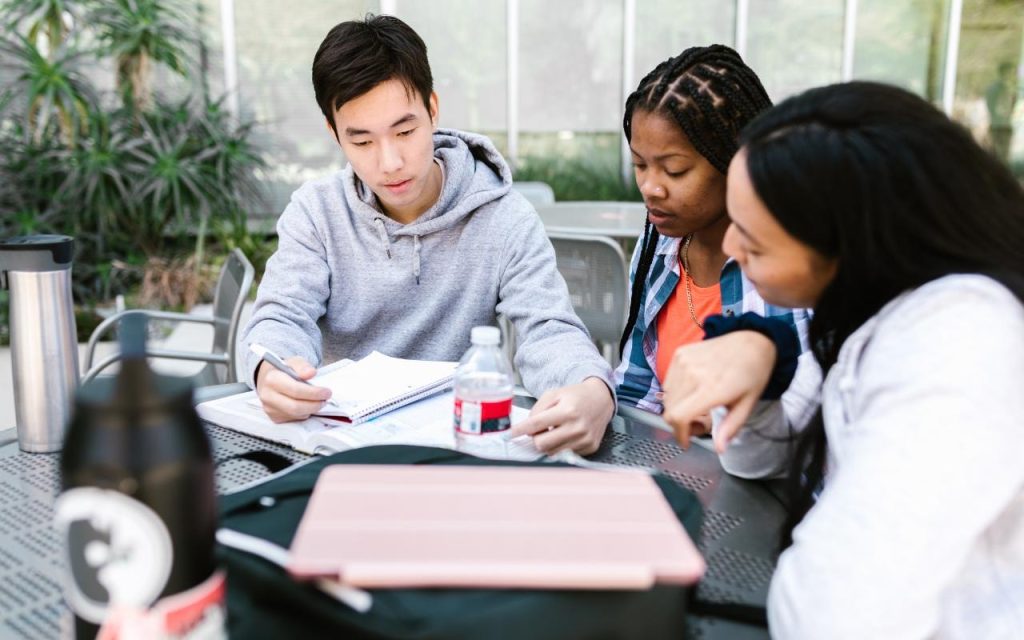 students study outdoors around table