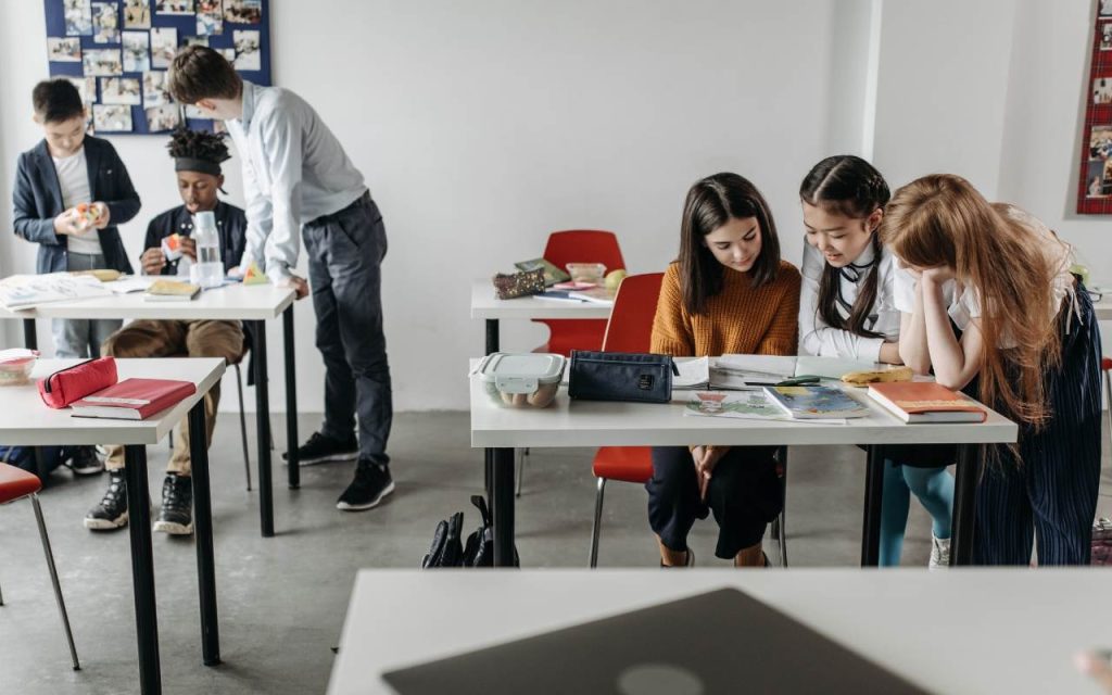 students gather around desks in groups of threes