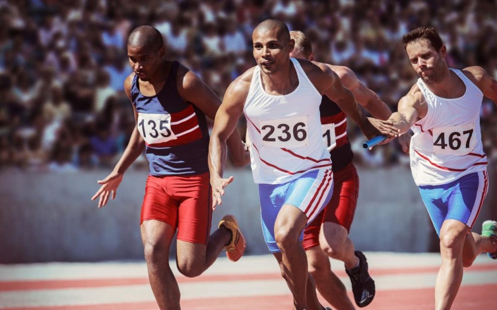 track athletes pass baton in a race