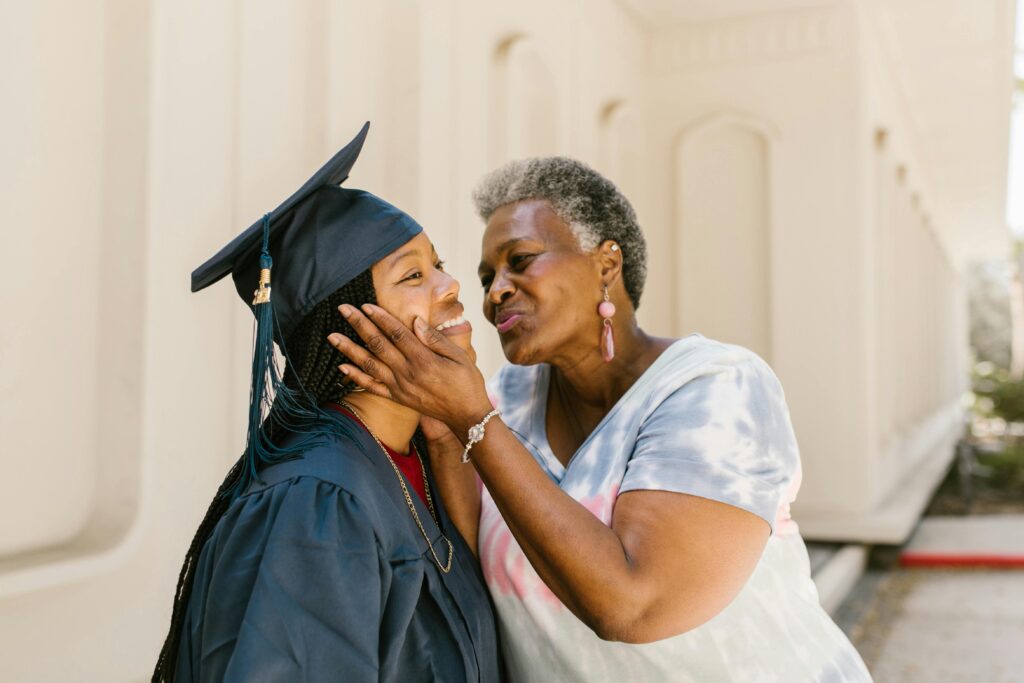 Proud mother kissing graduate.